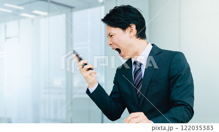 スマホに向かって大声で怒る男性・ビジネスマン 122035383