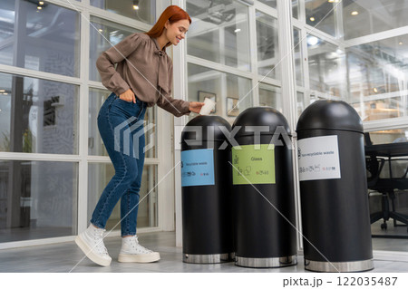 Woman choosing a proper container for throwing paper cup 122035487