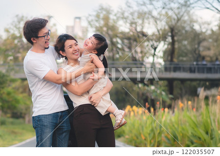 Happy Asian Family Enjoying Quality Time in Nature Park with Warm Smiles and Laughter 122035507