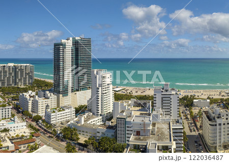 Tourism infrastructure in southern USA. South Beach sandy surface with tourists relaxing on hot Florida sun. Miami Beach city with high luxury hotels and condos 122036487