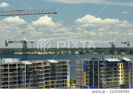 Tower lifting cranes at high residential apartment buildings construction site. Real estate development 122036492