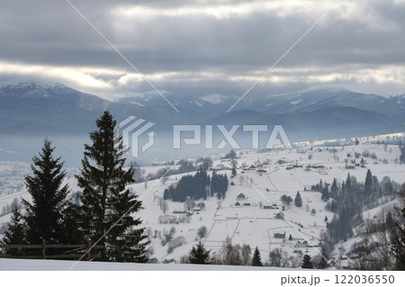 Winter landscape with dark spruse trees of snow covered forest in cold mountains 122036550