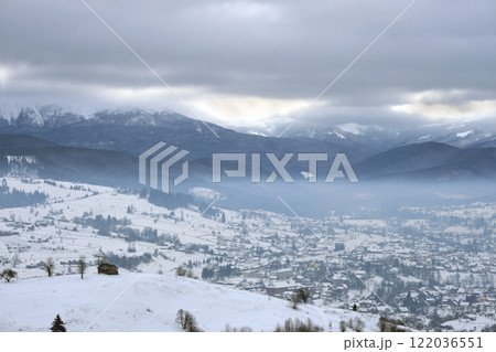 Winter landscape with small village houses between snow covered forest in cold mountains 122036551
