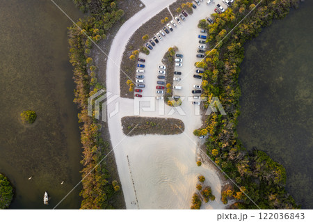 Parking lot for tourists cars in front of ocean beach with soft white sand in Florida. Popular vacation spot at sunset Parking lot for tourists cars in front of ocean beach with soft white sand in Florida. Popular vacation spot at sunset 122036843