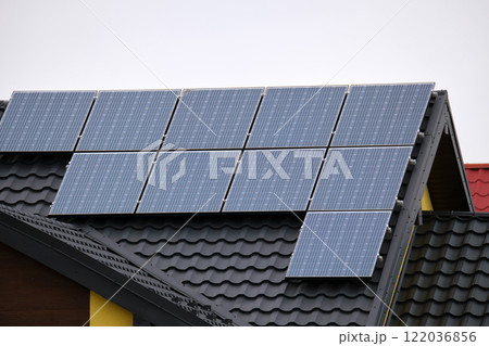 Private home roof covered with solar photovoltaic panels for generating of clean ecological electric energy in suburban rural town area. Concept of autonomous house Private home roof covered with solar photovoltaic panels for generating of clean ecological electric energy in suburban rural town area. Concept of autonomous house 122036856