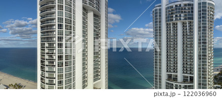 High angle view of Sunny Isles Beach city with expensive highrise hotels and condo buildings on Atlantic ocean shore. American tourism infrastructure in coastal southern Florida 122036960