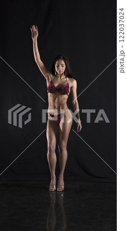 Beautiful athletic girl on a dark background Beautiful athletic girl on a dark background 122037024