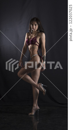 Beautiful athletic girl on a dark background Beautiful athletic girl on a dark background 122037025