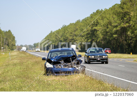 Damaged car crashed in traffic accident parked on highway side. Abandoned broken vehicle Damaged car crashed in traffic accident parked on highway side. Abandoned broken vehicle 122037060