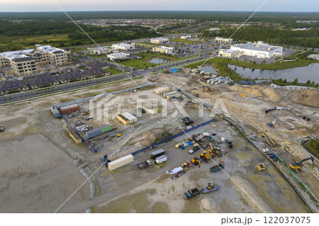 Development of residential housing in US suburbs. Beginning of construction works on prepared ground. Large building site with scattered equipment in american rural area. Real estate market in USA 122037075