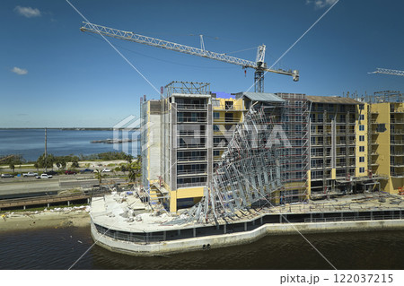 Aerial view of ruined by hurricane Ian construction scaffolding on high apartment building site in Port Charlotte, USA Aerial view of ruined by hurricane Ian construction scaffolding on high apartment building site in Port Charlotte, USA 122037215