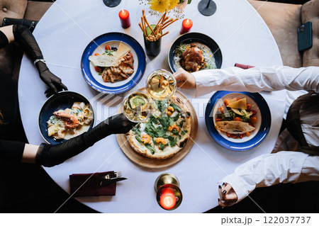 Celebratory dinner with wine, gourmet dishes, and elegance at a fine dining table setting 122037737