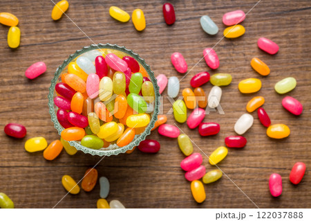 Multicolored jelly beans with various flavors in glass bowl on wooden table. Multicolored jelly beans with various flavors in glass bowl on wooden table. 122037888