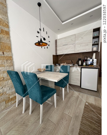 Modern dining table with teal chairs and a minimalist design. A clean bright interior with a mix of natural and contemporary elements, creating a welcoming atmosphere. Minimalism, modern home, dining Modern dining table with teal chairs and a minimalist design. A clean bright interior with a mix of natural and contemporary elements, creating a welcoming atmosphere. Minimalism, modern home, dining 122038597