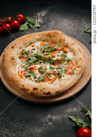 Gourmet pizza with smoked salmon, arugula, and capers on a wooden board for a delicious meal 122038767