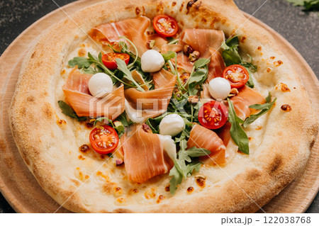 Gourmet pizza with prosciutto, mozzarella, arugula, and cherry tomatoes, food lover's feast Gourmet pizza with prosciutto, mozzarella, arugula, and cherry tomatoes, food lover's feast 122038768