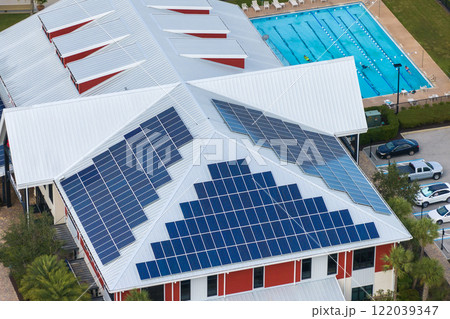Solar rooftop on commercial center in Florida. Photovoltaic panels for producing of clean ecological electrical energy in city urban area. Concept of autonomous building Solar rooftop on commercial center in Florida. Photovoltaic panels for producing of clean ecological electrical energy in city urban area. Concept of autonomous building 122039347