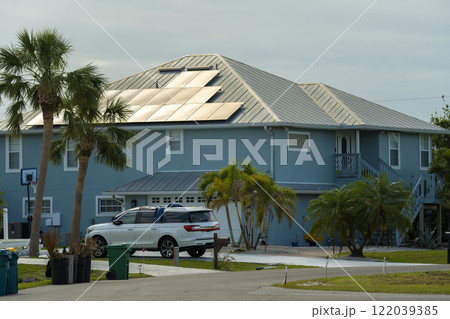 Residential house with rooftop covered with solar photovoltaic panels for producing of clean ecological electrical energy in suburban rural area. Concept of autonomous home 122039385