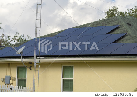 Residential house with rooftop covered with solar photovoltaic panels for producing of clean ecological electrical energy in suburban rural area. Concept of autonomous home 122039386