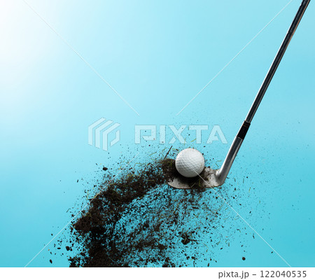 Golf ball explode from Tee off. Golfer hit ball with metal iron club to grass soil explosion on green. Golf club hit ball on green tee off with grass flying scatter. Blue Sky background isolated 122040535