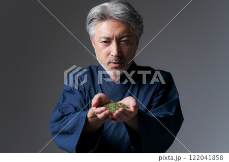 緑茶の茶葉を持つ作務衣の男性 122041858