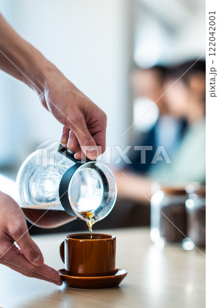 落ち着いたカフェで窓辺に座るカップル 122042001