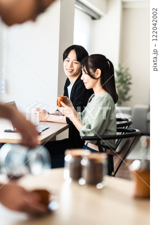 落ち着いたカフェで窓辺に座るカップル 落ち着いたカフェで窓辺に座るカップル 122042002