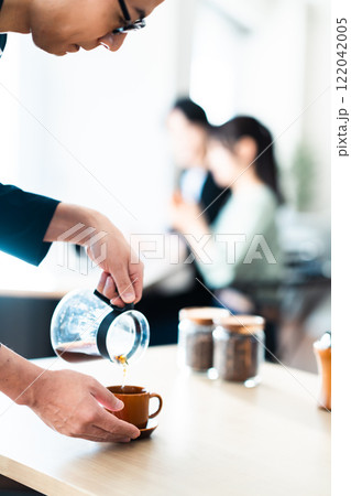 落ち着いたカフェで窓辺に座るカップル 122042005