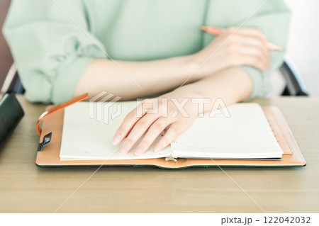 手帳を開く若い女性 手元 手帳を開く若い女性 手元 122042032