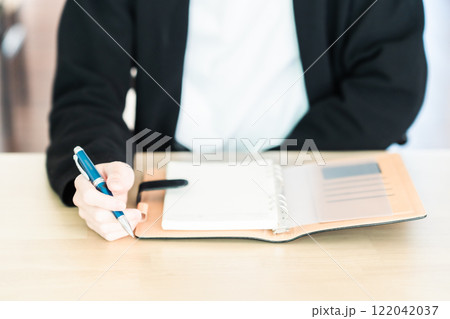 手帳を前にして考えるビジネスマン　顔無し 122042037