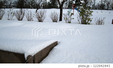 冬の晴れ間の雪積もって真っ白な公園 122042841