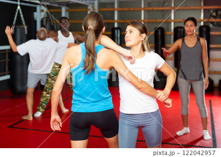 Girl self defense training gym learning to do painful grip 122042957