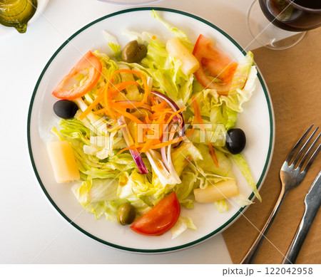 Fresh mixed salad with lettuce, cabbage, carrots, onions, tomatoes, olives. Spanish dish ensalada variada 122042958
