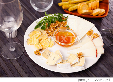 Varieties of cheese sliced and served with honey 122042961