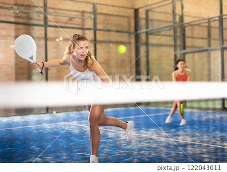 Young beautiful woman with racket playing padel Young beautiful woman with racket playing padel 122043011