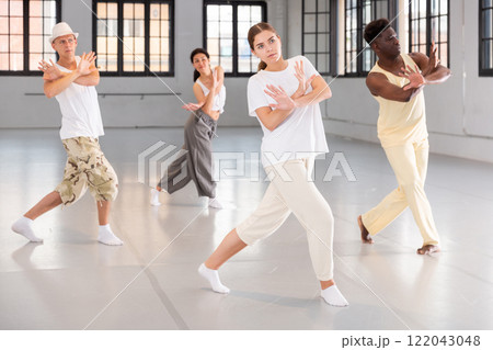Four dancers exercising contemporary dance movements 122043048