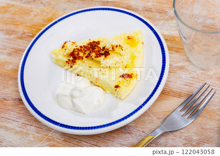 There is piece of casserole on plate, made from cottage cheese There is piece of casserole on plate, made from cottage cheese 122043058