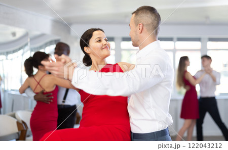 Adult man and young woman dance tango Adult man and young woman dance tango 122043212