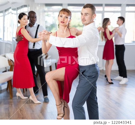 Young man and woman dancing tango in couple during lesson at studio 122043341