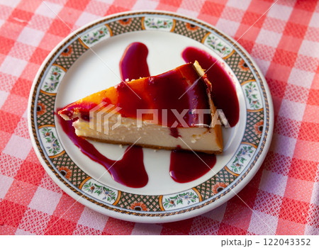 Slice of delicious classical cheesecake with fruity sauce served in cafeteria Slice of delicious classical cheesecake with fruity sauce served in cafeteria 122043352
