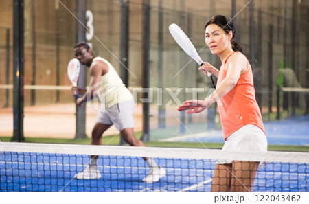 Young asian woman playing padel on a hard court Young asian woman playing padel on a hard court 122043462