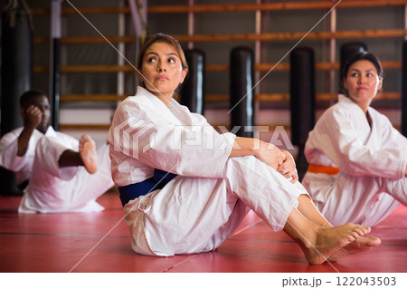 Multiracial group of people in kimono doing crunches 122043503