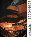 グリルで焼かれる肉と手元 122044623