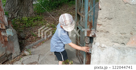 Curious boy with backpack exploring mysterious and eerie abandoned house with secrets and surprises Curious boy with backpack exploring mysterious and eerie abandoned house with secrets and surprises 122044741