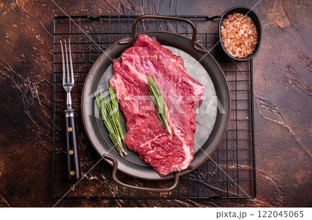 Raw hanger tender beef steak, skirt steak with rosemary on steel tray. brown background. top view Raw hanger tender beef steak, skirt steak with rosemary on steel tray. brown background. top view 122045065