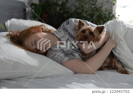 Cozy Morning Scene A Woman Enjoying a Peaceful Sleep While Snuggled Up With Her Dog In Bed Cozy Morning Scene A Woman Enjoying a Peaceful Sleep While Snuggled Up With Her Dog In Bed 122045702