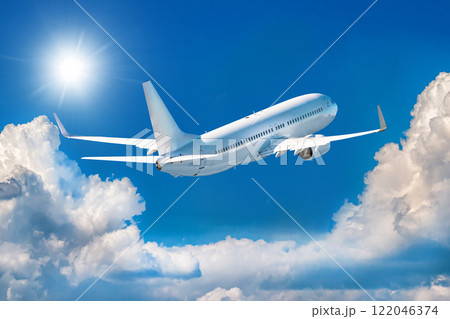 White passenger airplane is climbing in the air above picturesque clouds White passenger airplane is climbing in the air above picturesque clouds 122046374