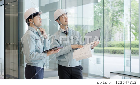 打ち合わせをする作業服を着た男性 打ち合わせをする作業服を着た男性 122047812