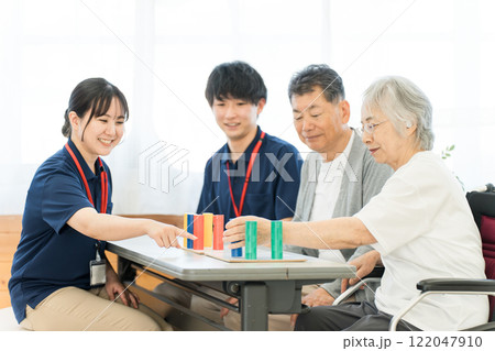 介護施設・リハビリ施設で働く作業療法士の職員とリハビリをするシニア女性 介護施設・リハビリ施設で働く作業療法士の職員とリハビリをするシニア女性 122047910