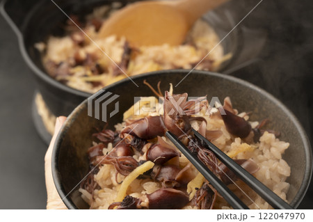 土鍋で炊いたホタルイカの炊き込みご飯を箸で持ち上げる 土鍋で炊いたホタルイカの炊き込みご飯を箸で持ち上げる 122047970